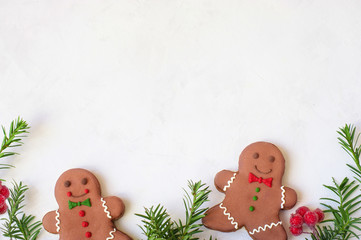 Two gingerbread man with candy standing on a white background. Christmas card