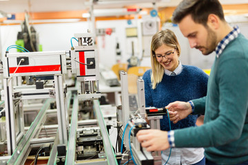 Young attractive students of mechatronics working on project