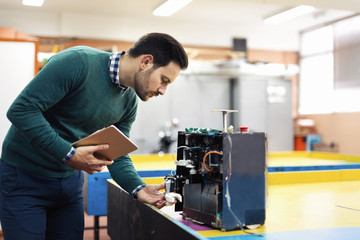 Young student of mechatronics working on project