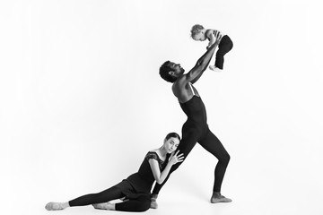 A happy family of ballet dancers on white studio background