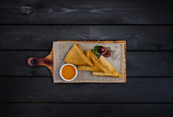 Thin pancakes or russian blini with honey leaf of mint and grapes. On a wooden board. Top view....
