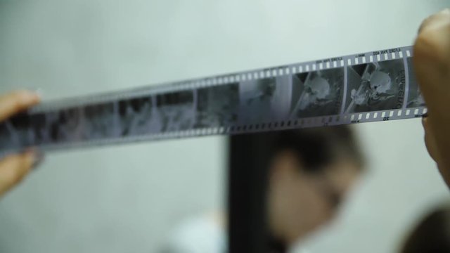 Photographer looking on negative film. Done work inspecting. Old fashioned photographing. Photographer inspecting negative film