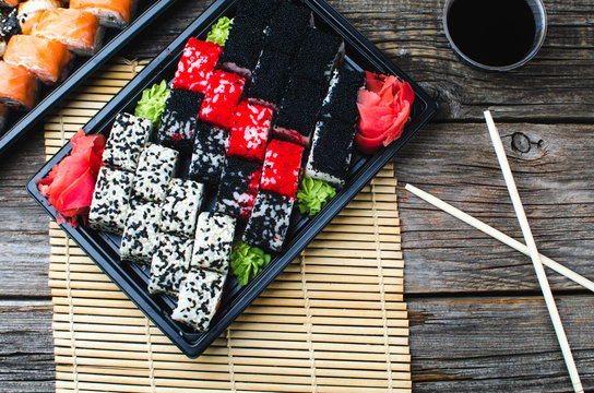 Sushi in a black container on a wooden table colorful and beautiful