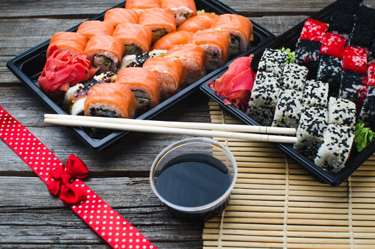 Sushi in a black container on a wooden table colorful and beautiful