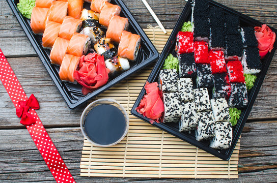 Sushi in a black container on a wooden table colorful and beautiful