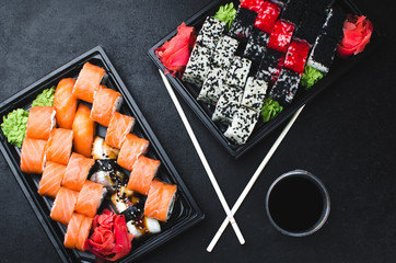 Sushi in a black container on a wooden table colorful and beautiful