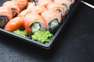 Sushi in a black container on a wooden table colorful and beautiful