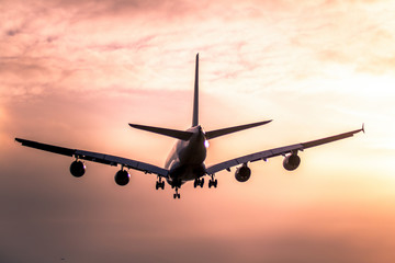 Airplane landing at sunset