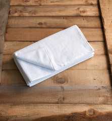 modern bathrobe bath soap and loofah brush behind wooden table