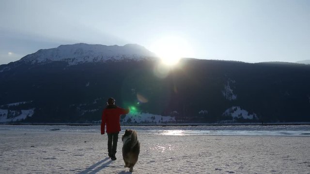 Un uomo rende omaggio al tramonto insieme al suo affezionatissimo cane