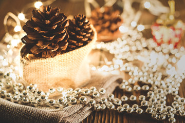 Pine cones put on grey cloth and Christmas party accessories on wooden table