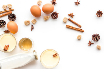 Ingredients for eggnog. Eggs, milk, cinnamon, whiskey on white background top view copyspace