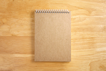 Brown blank spiral notebook on wood background