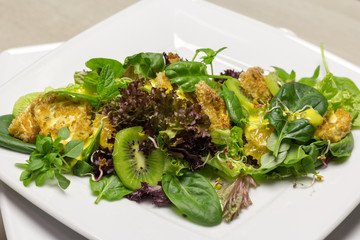  Green Salad with different lettuce  with Orange Chicken and Kiwi on White Porcelain Plate clouse up 