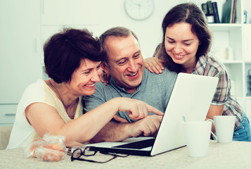 Obraz premium senior couple and daughter with laptop at home.