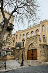 Fototapeta na wymiar View at the Sabir Street and om the left Embassy of Switzerland. Walking on empty, morning street in old town of Baku city. Ancient stone buildings.