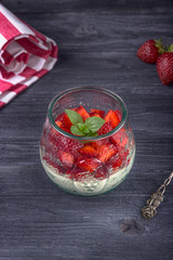 Homemade dessert panna cotta with fresh strawberries and mint on a gray wooden background