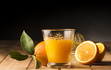 Glass with orange juice on the wooden table