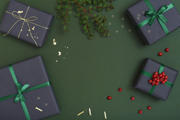 Christmas gifts on dark green background with copy space, flat lay