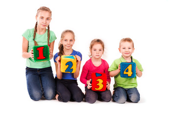 Happy kids holding blocks with numbers over white background