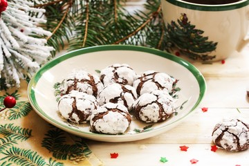 Homemade Chocolate Crinkle cookies in white and green Christmas plate, selective focus