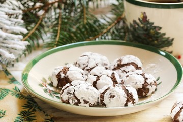 Homemade Chocolate Crinkle cookies in white and green Christmas plate, selective focus
