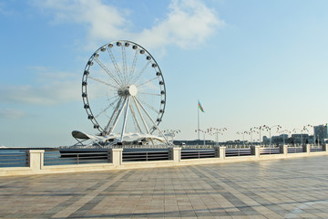 Baku eye on Seaside Boulevard. Baku ferris wheel. In the sunny winter day. Deserted boulevard