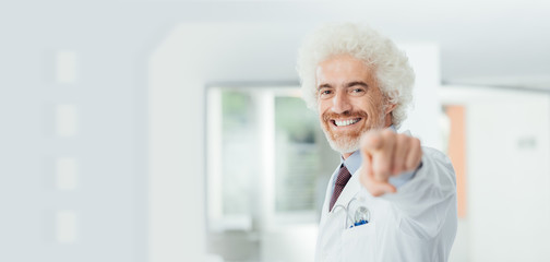 Fototapeta na wymiar Cheerful doctor pointing at camera