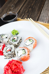 on the plate is white, lined with different rolls, sushi