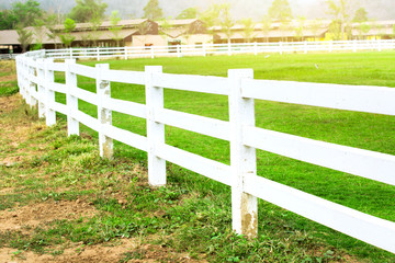 White concrete fence in farm field with sunlight