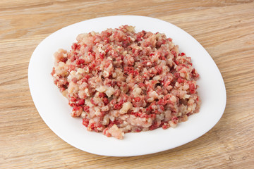 Raw ground meat on a white plate. Minced meat from pork and chicken on a plate.