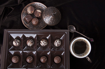 Box with chocolates and a cup of coffee