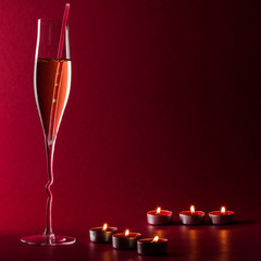 Valentine mood with a glass of champage, candles and a drinking straw - 182741576