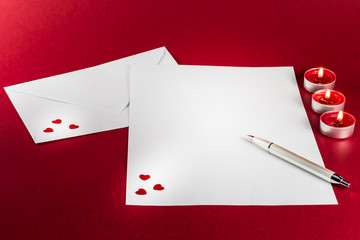 Valentines love letter writing setup, with envelope, paper, red hearts and candles - 182741586