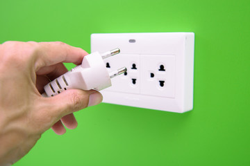 Hand hold electric power plug and inserting into power wall socket
