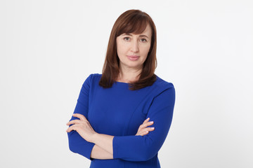 Portrait of brunette serious woman in blank white t-shirt. Crossed arms on chest. Copy space on white background. Mock up and mother day