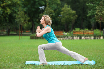 Elderly woman doing yoga in park