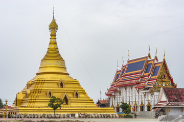 Naklejka premium a large golden pagoda with a smaller, white building next to it. Both buildings have elaborate, ornate roofs.