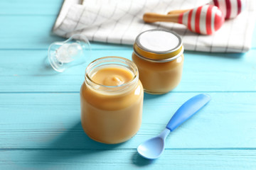 Bowl with yummy spirulina smoothie and bottle of drink on wooden table. Healthy vegan food concept