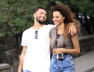 Cheerful young couple walking on urban street