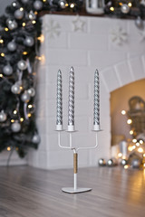Triple candle holder with beautiful patterned candles on the background