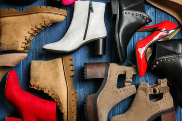 Various female stylish shoes on wooden background