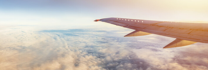 Obraz premium Skrzydło samolotu pod ziemią i chmurami. Lot na niebie.