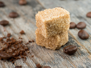 Brown cane sugar with coffee beans on rustic wooden background
