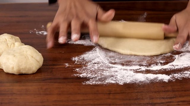 Indian Woman Rolling Out Chapati using Rolling pin on a Wooden Table  - Closeup Shot 