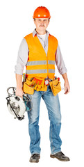 builder in a helmet holding a circular saw and looking at camera