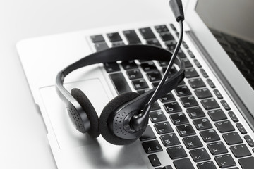 call center support concept. headset on keyboard computer laptop