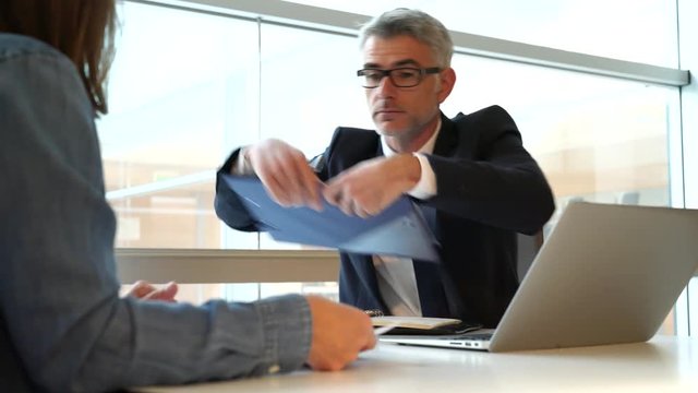 Woman in banker's office signing financial loan for project