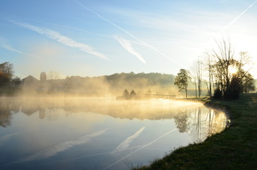 Foggy morning sunrise over a lake with bridge