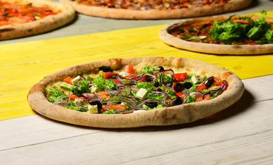 Takeaway food with crunchy edges. Greek pizza with black olives